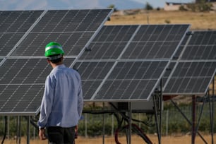 Un uomo in piedi davanti a una fila di pannelli solari