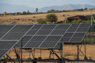 a row of solar panels sitting on top of a dry grass field