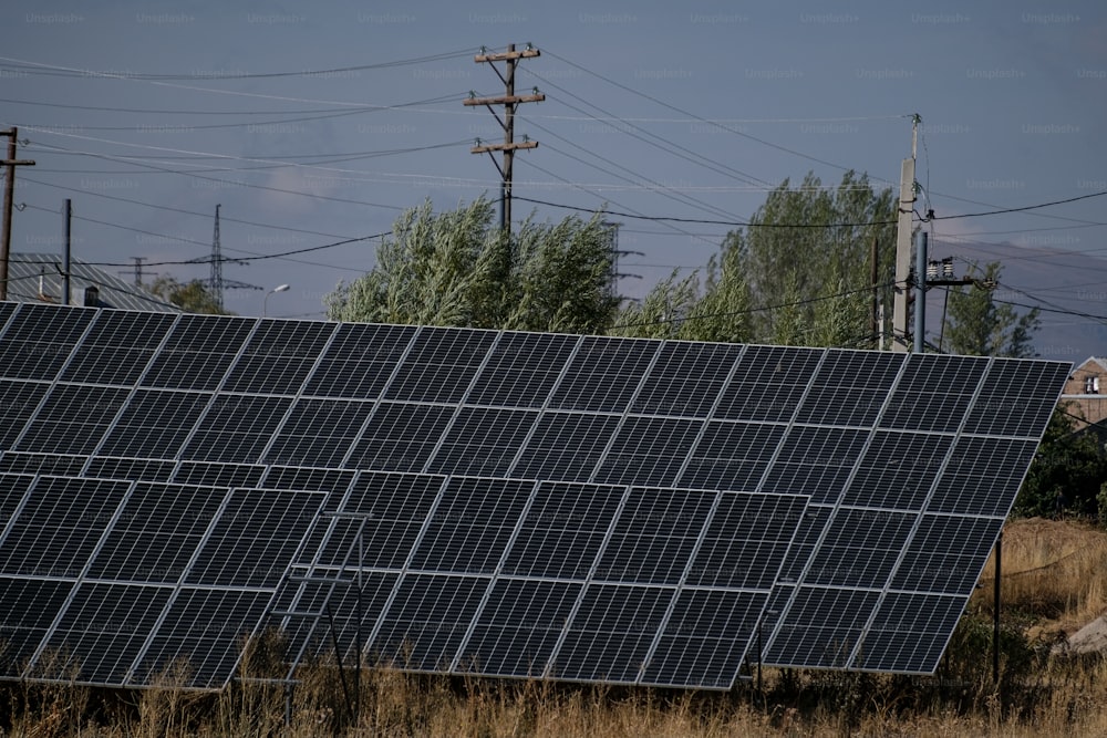 Un gran panel solar sentado en la parte superior de un campo de hierba seca
