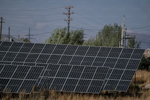 a large solar panel sitting on top of a dry grass field