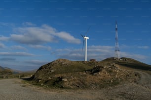 uma turbina eólica sentada no topo de uma colina