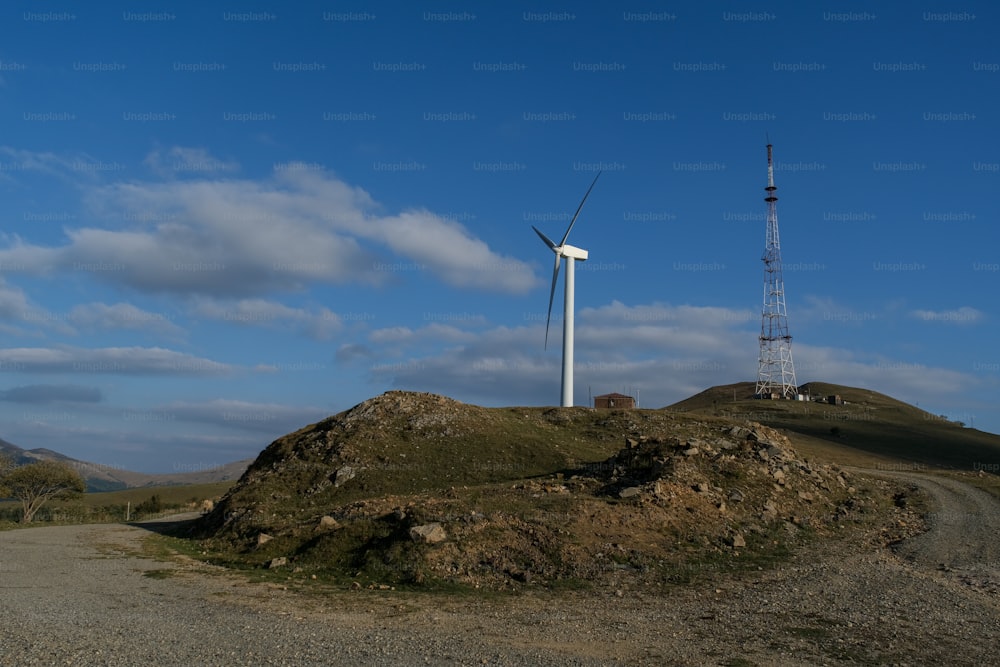 a wind turbine sitting on top of a hill