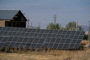 a row of solar panels sitting on top of a dry grass field