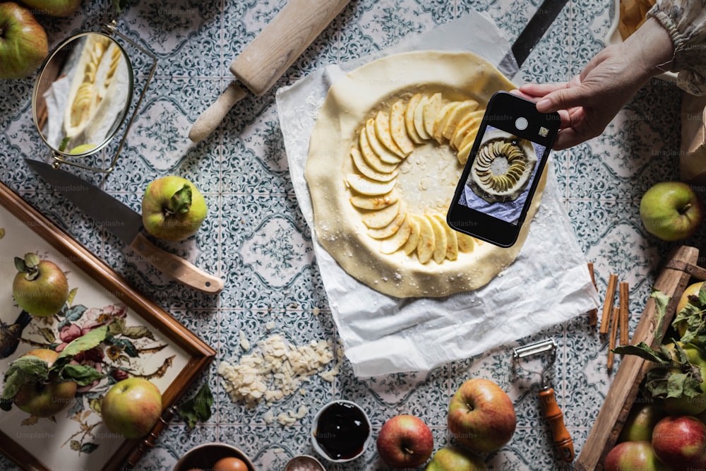 a person taking a picture of an apple pie