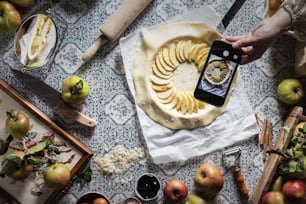 a person taking a picture of an apple pie