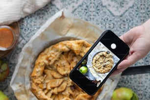 a person taking a picture of a pie