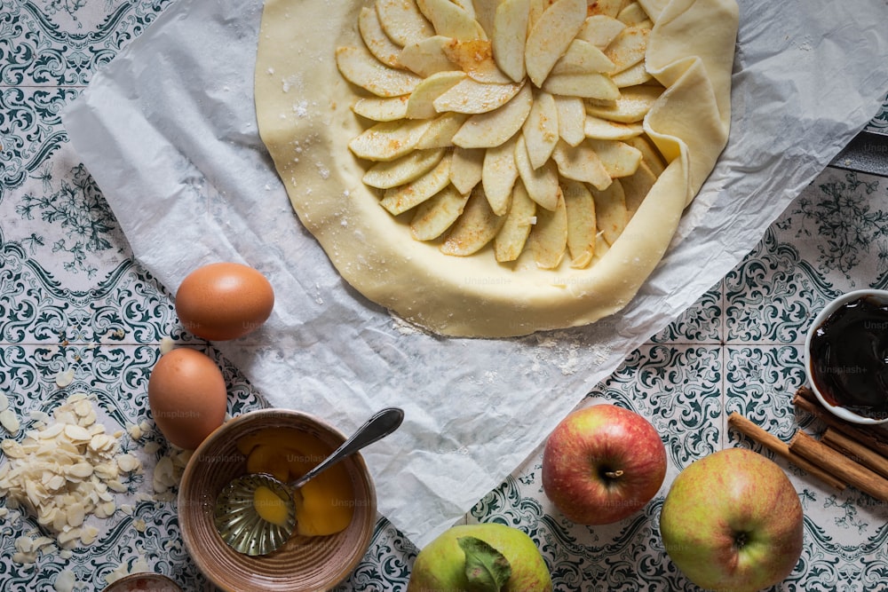 una mesa cubierta con un pastel cubierto de manzanas