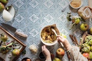 a bowl of food on a table surrounded by apples