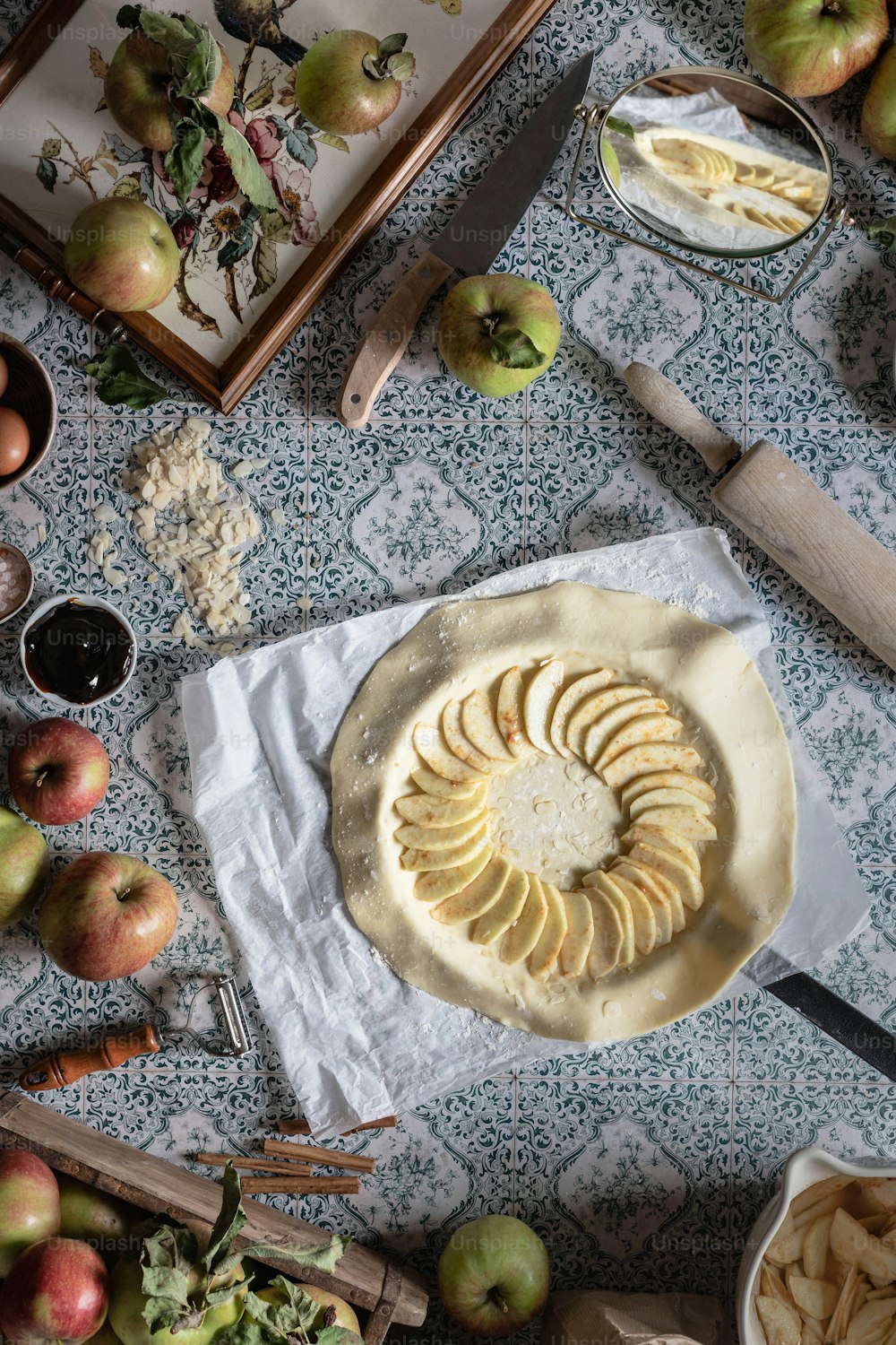 an apple pie with sliced apples on a table
