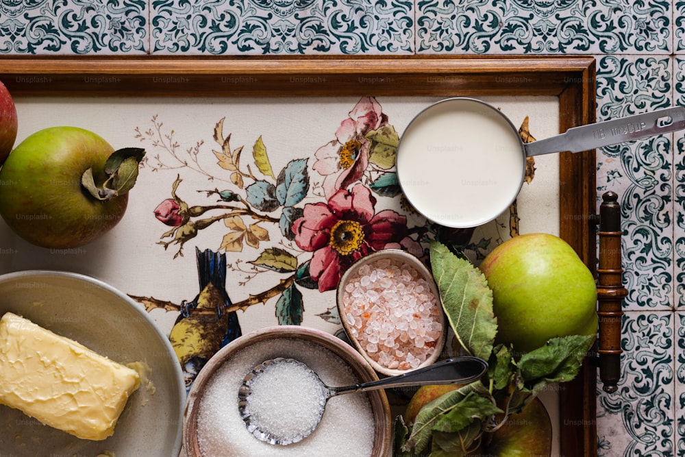 una bandeja con manzanas, queso y otros alimentos