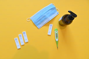 a disposable face mask and medical supplies on a yellow surface