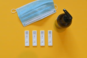 a disposable face mask next to four medical tags
