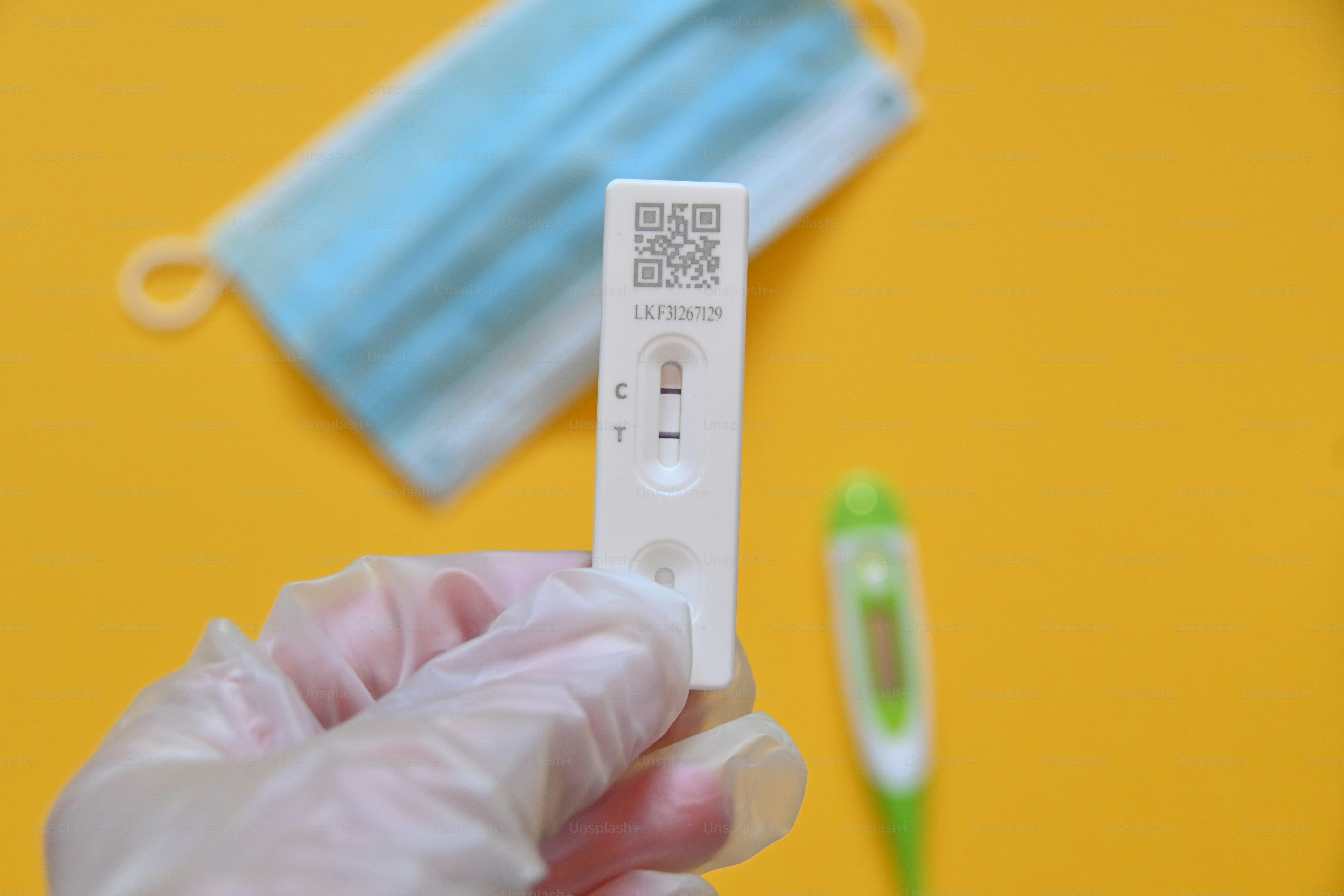 a person wearing a face mask and gloves holding a remote control