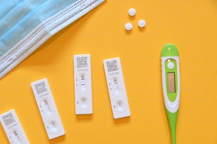 a green and white thermometer next to four other thermometers