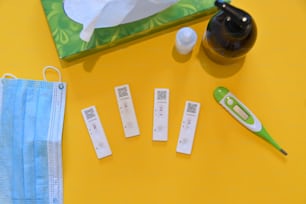 a yellow table topped with medical supplies and a face mask