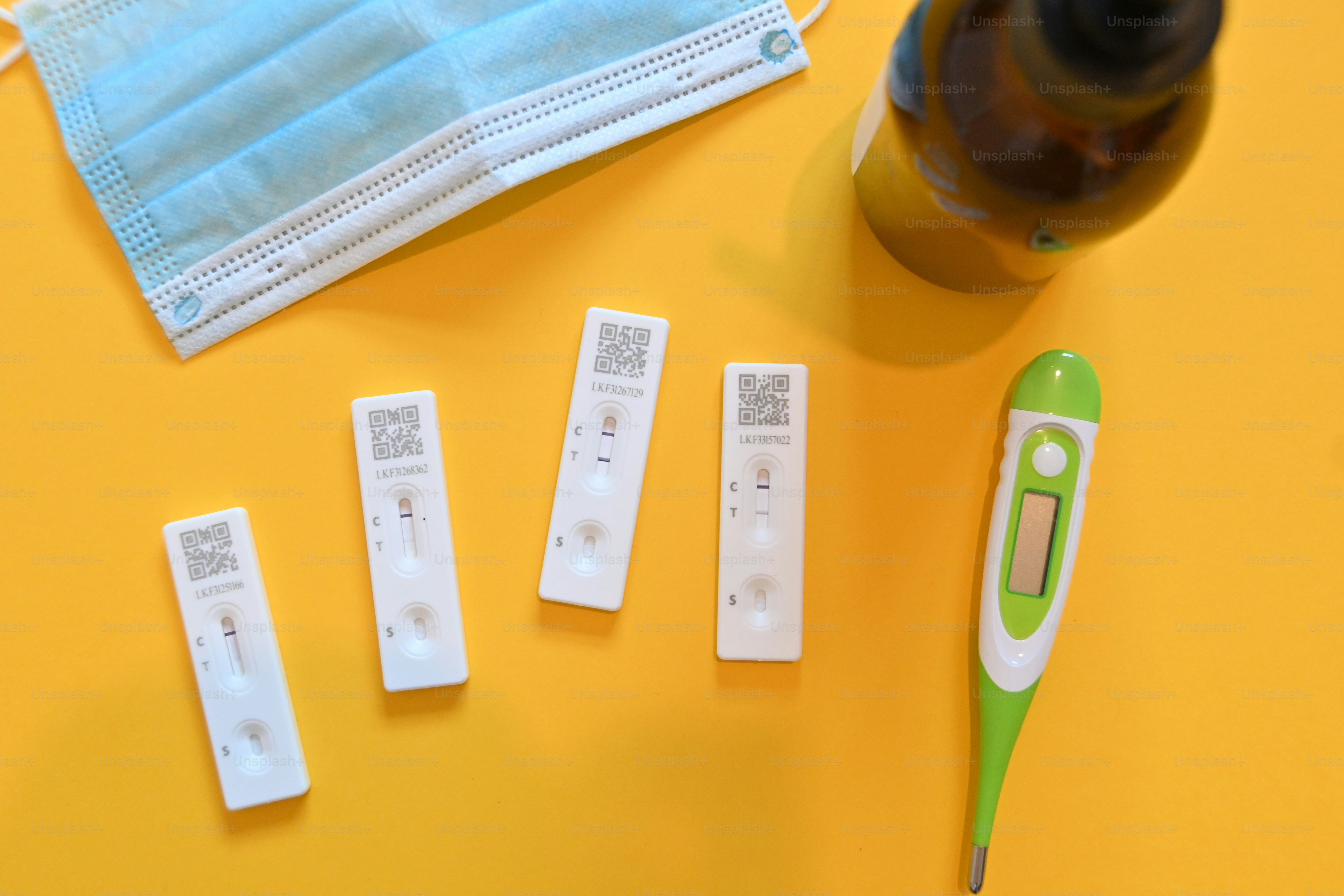 a green and white thermometer, a bottle of liquid, and five white