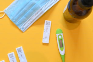 a green and white thermometer next to a bottle of alcohol