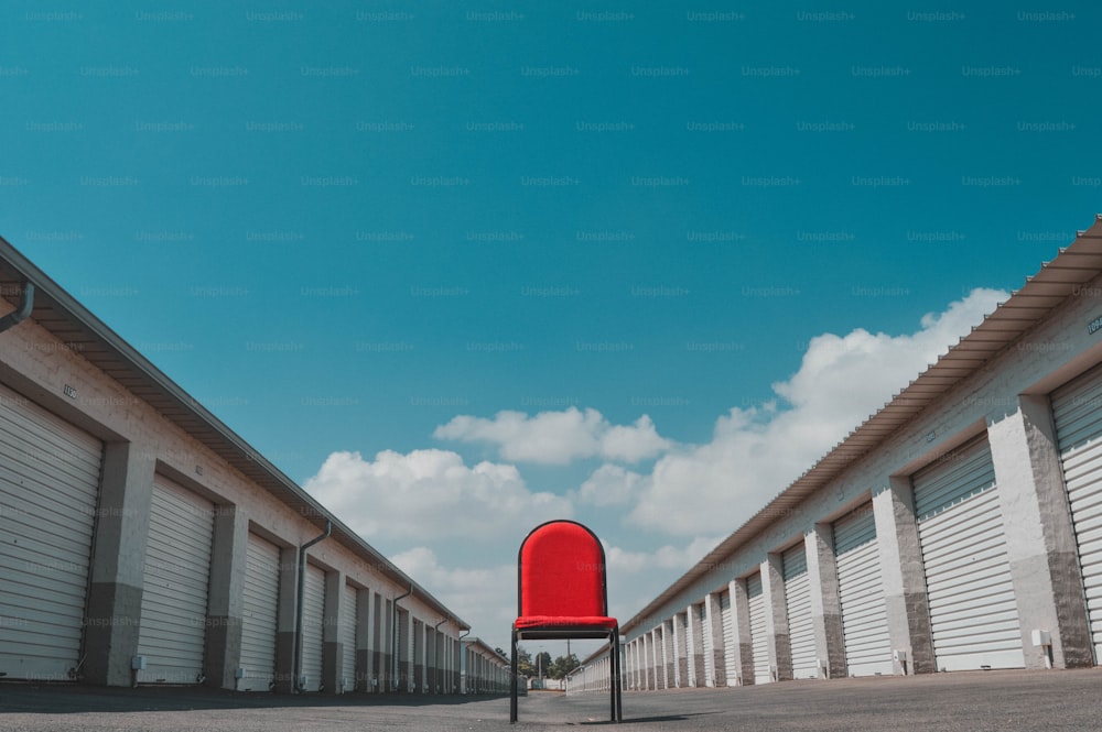a red chair sitting in front of a row of storage units