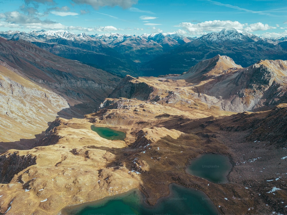 an aerial view of a mountain range with a lake in the foreground