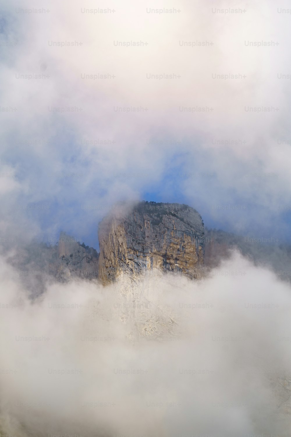 uma montanha nas nuvens com uma montanha ao fundo