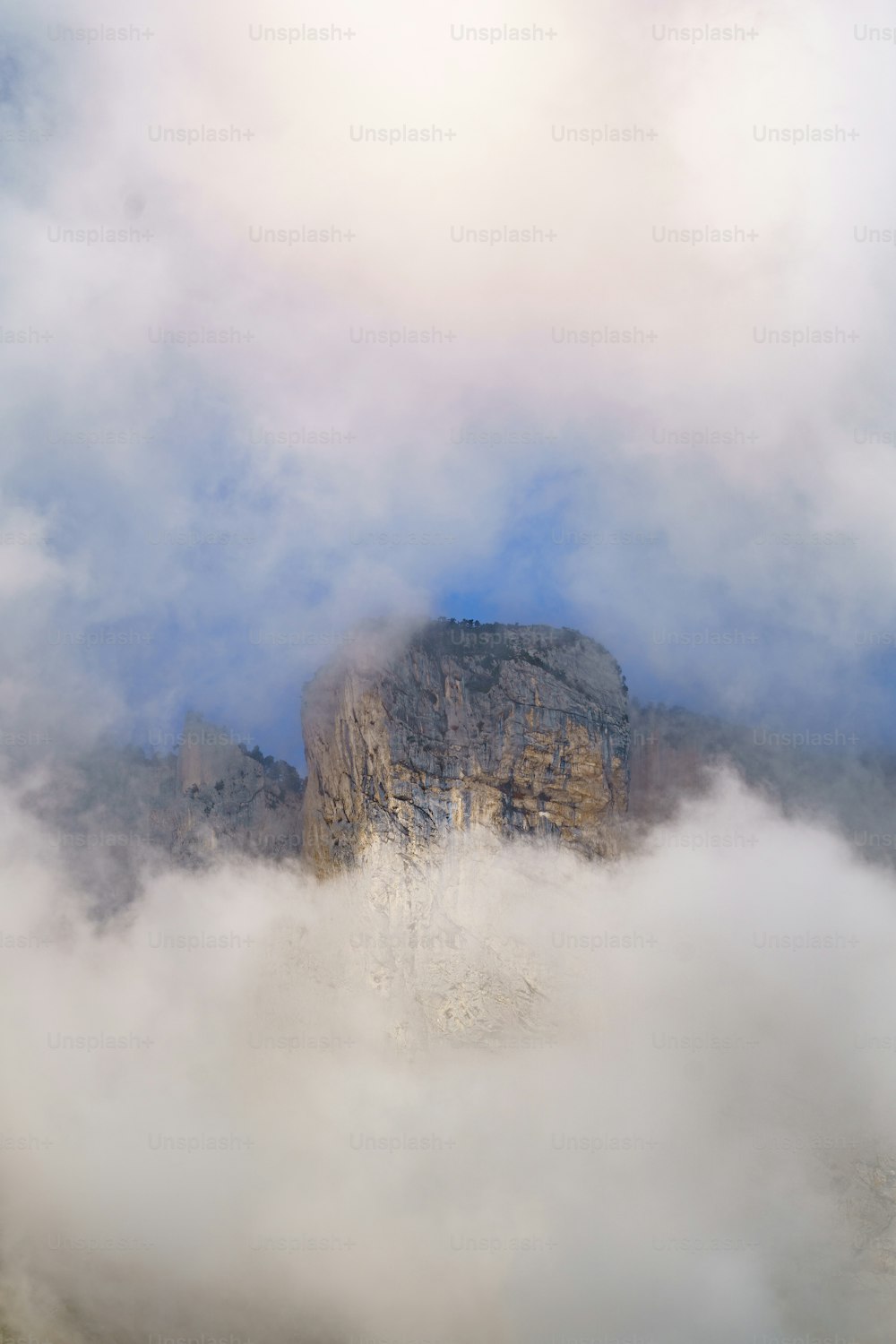 Ein Berg in den Wolken mit einem Berg im Hintergrund