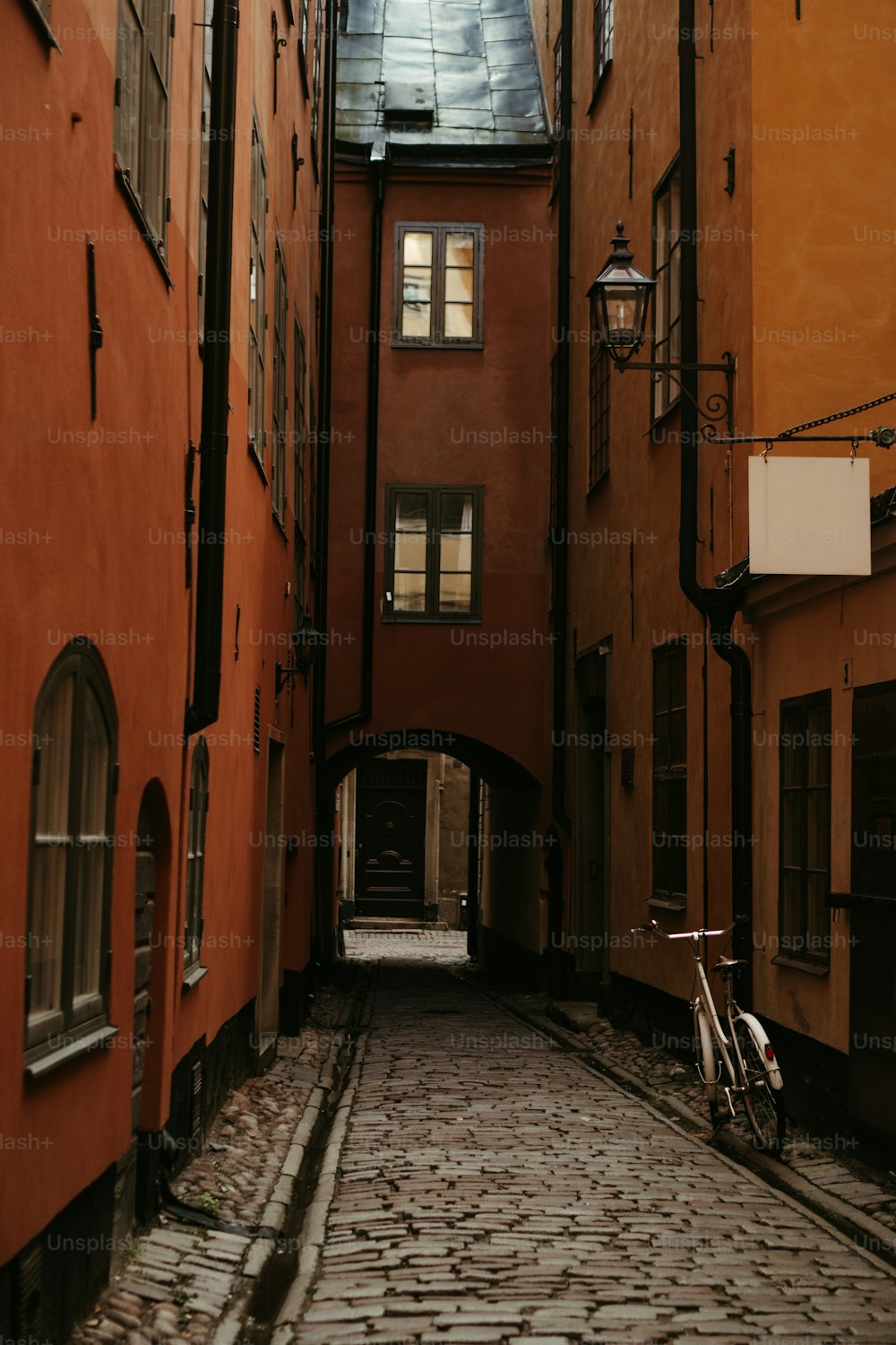 a bike is parked in an alley between two buildings