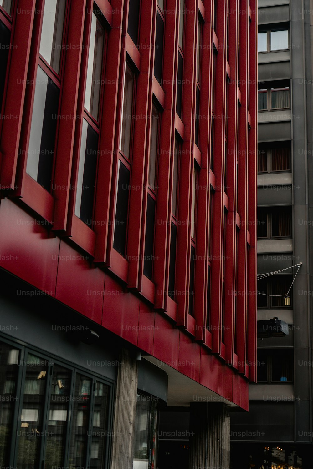 Un alto edificio rosso accanto a un alto edificio grigio