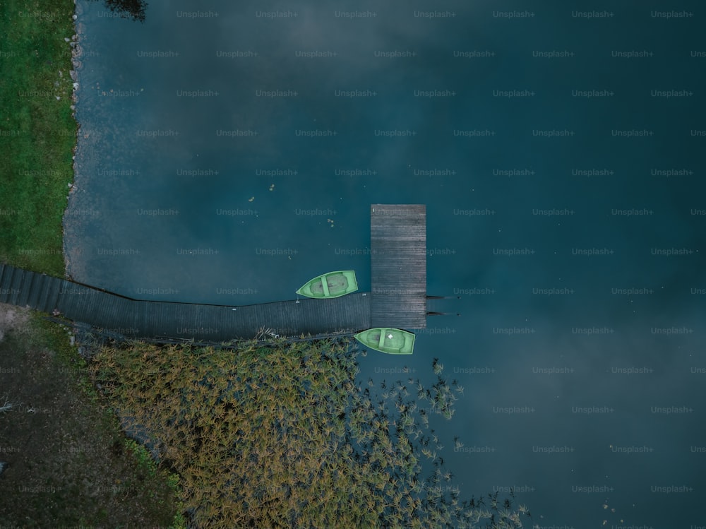 Ein paar grüne Kanus, die auf einem Gewässer sitzen