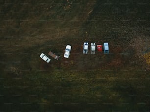 a group of four cars parked in a field