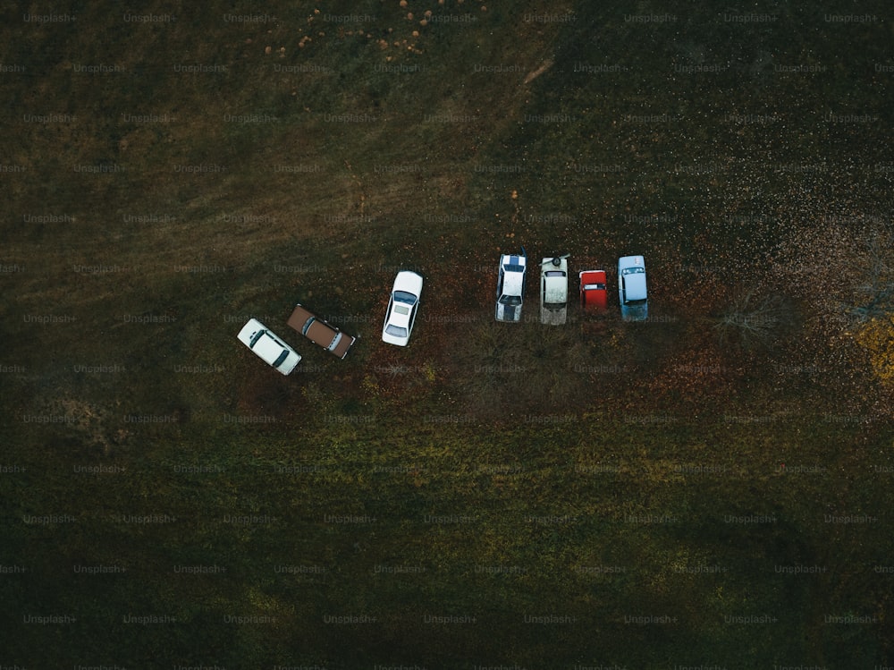 a group of four cars parked in a field