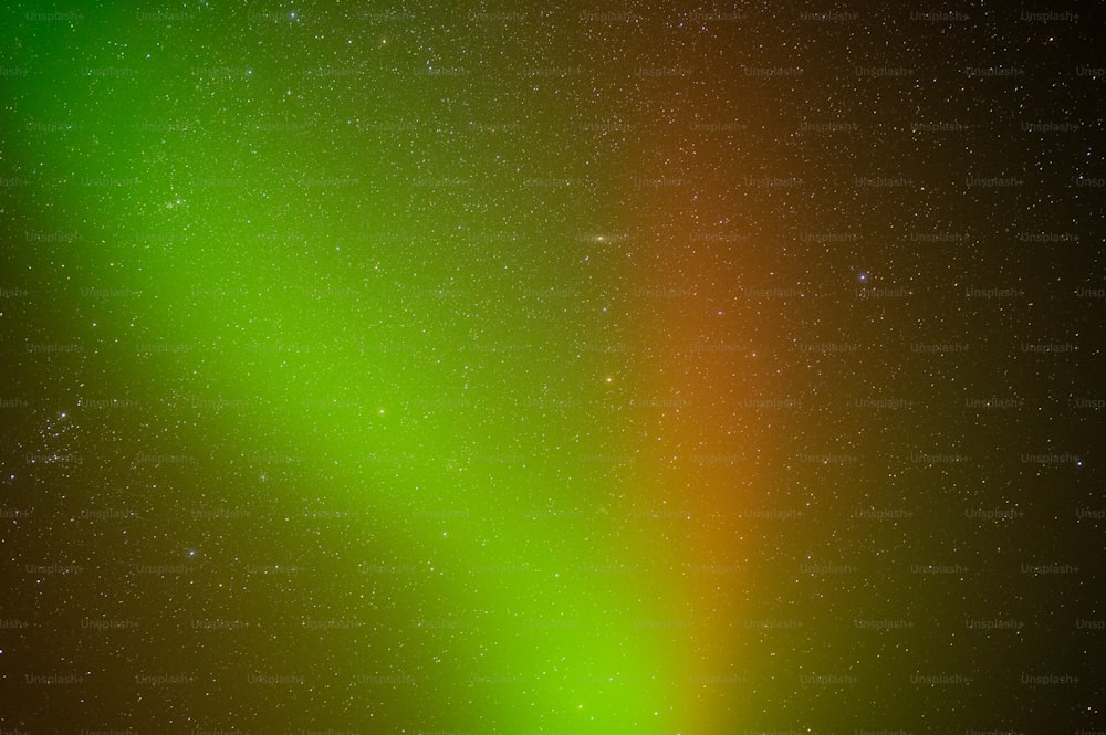 a bright green and orange aurora bore in the night sky