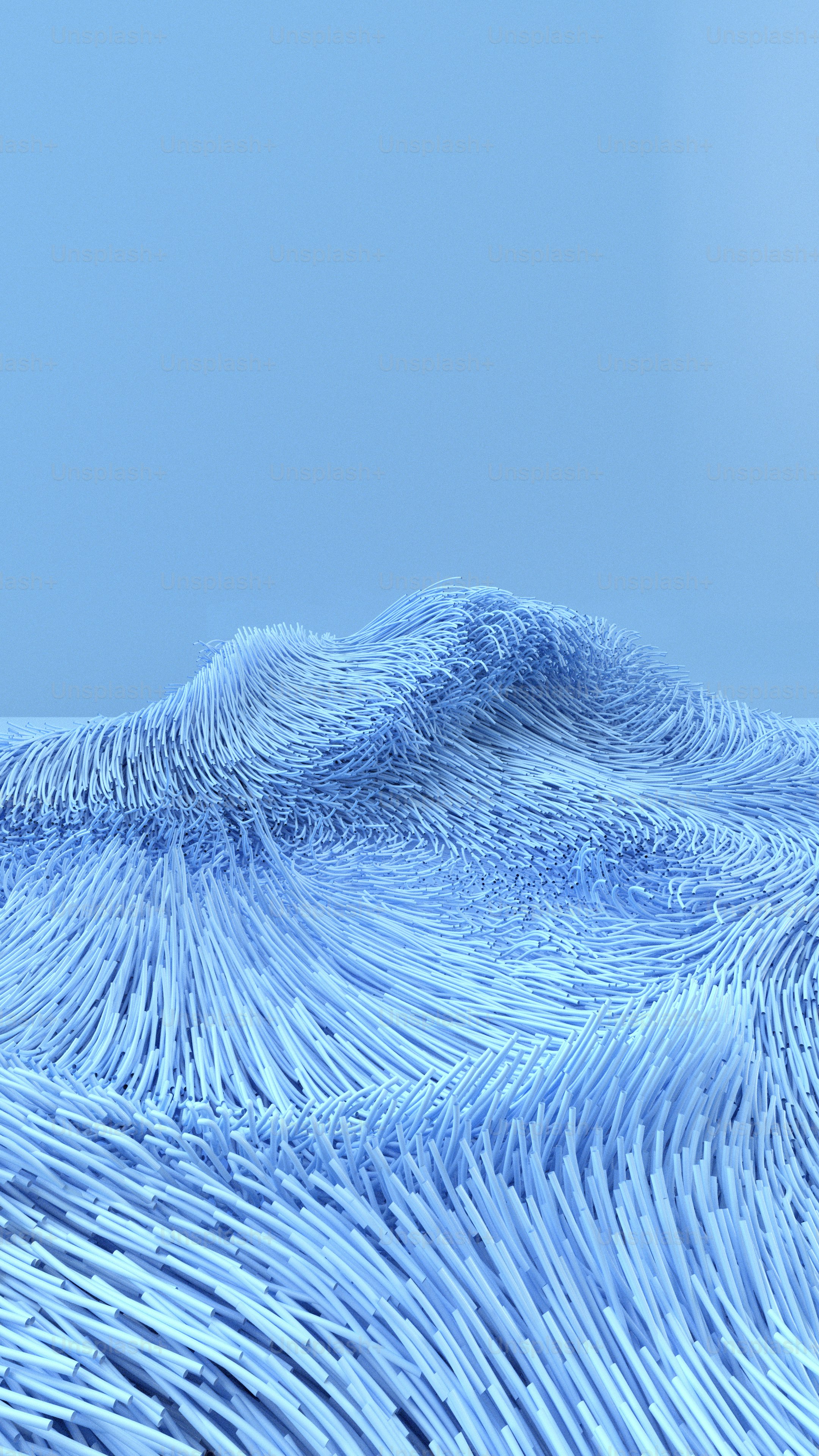 a large wave of blue water with a blue sky in the background