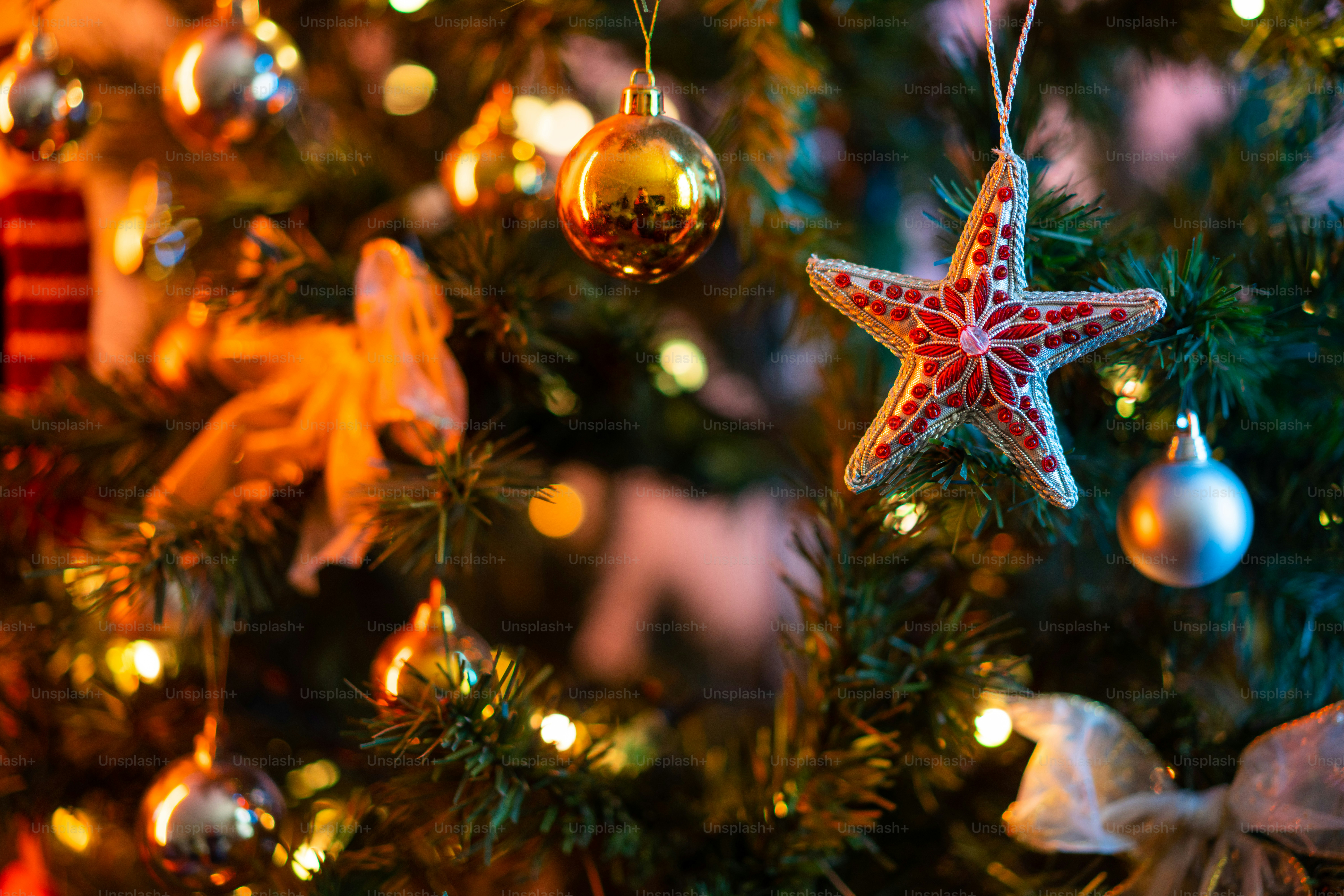 a star ornament hanging from a christmas tree