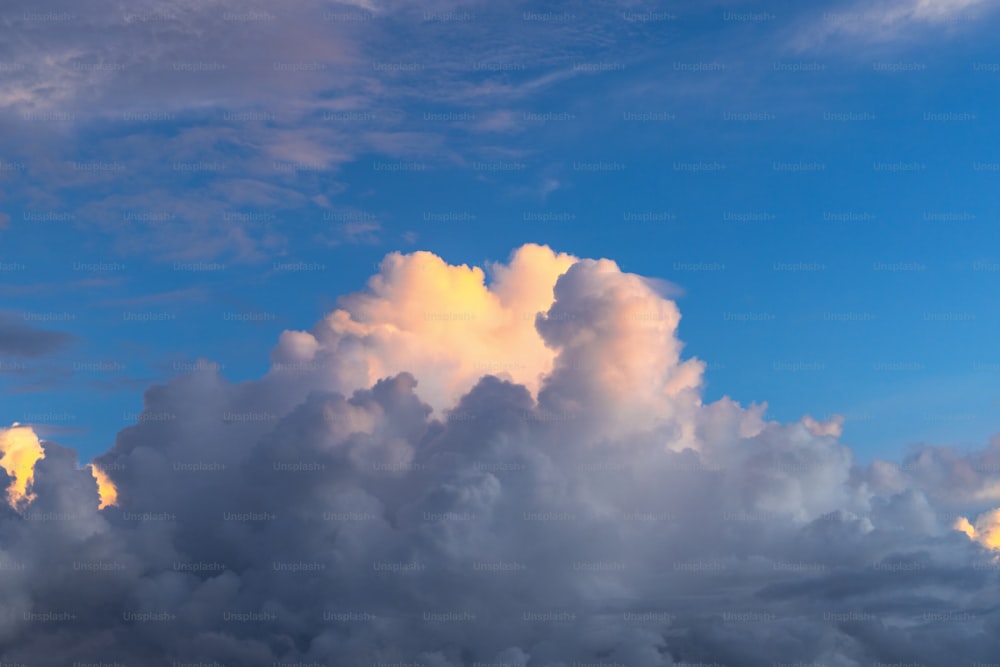 a plane flying through a cloudy blue sky