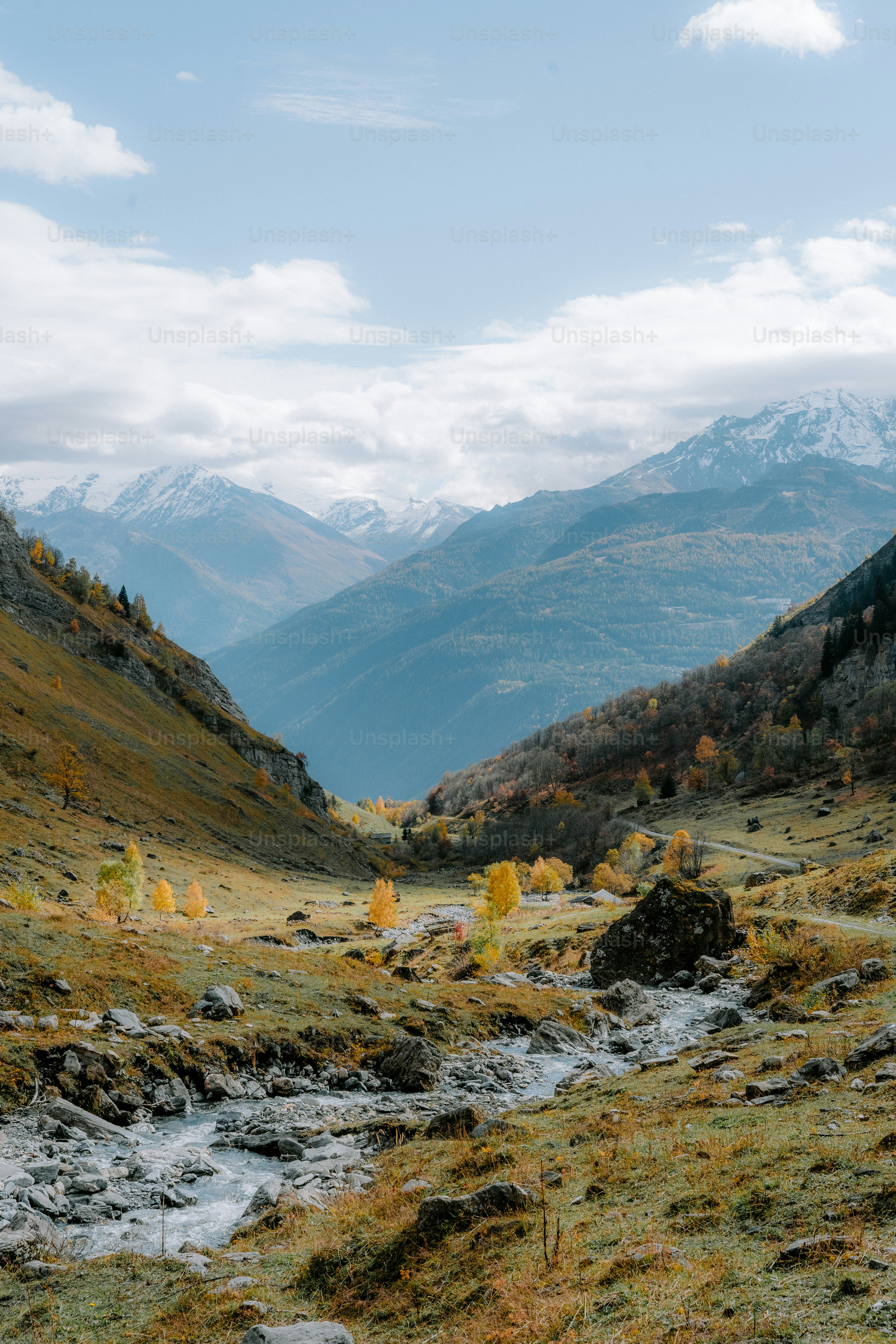a stream running through a valley surrounded by mountains