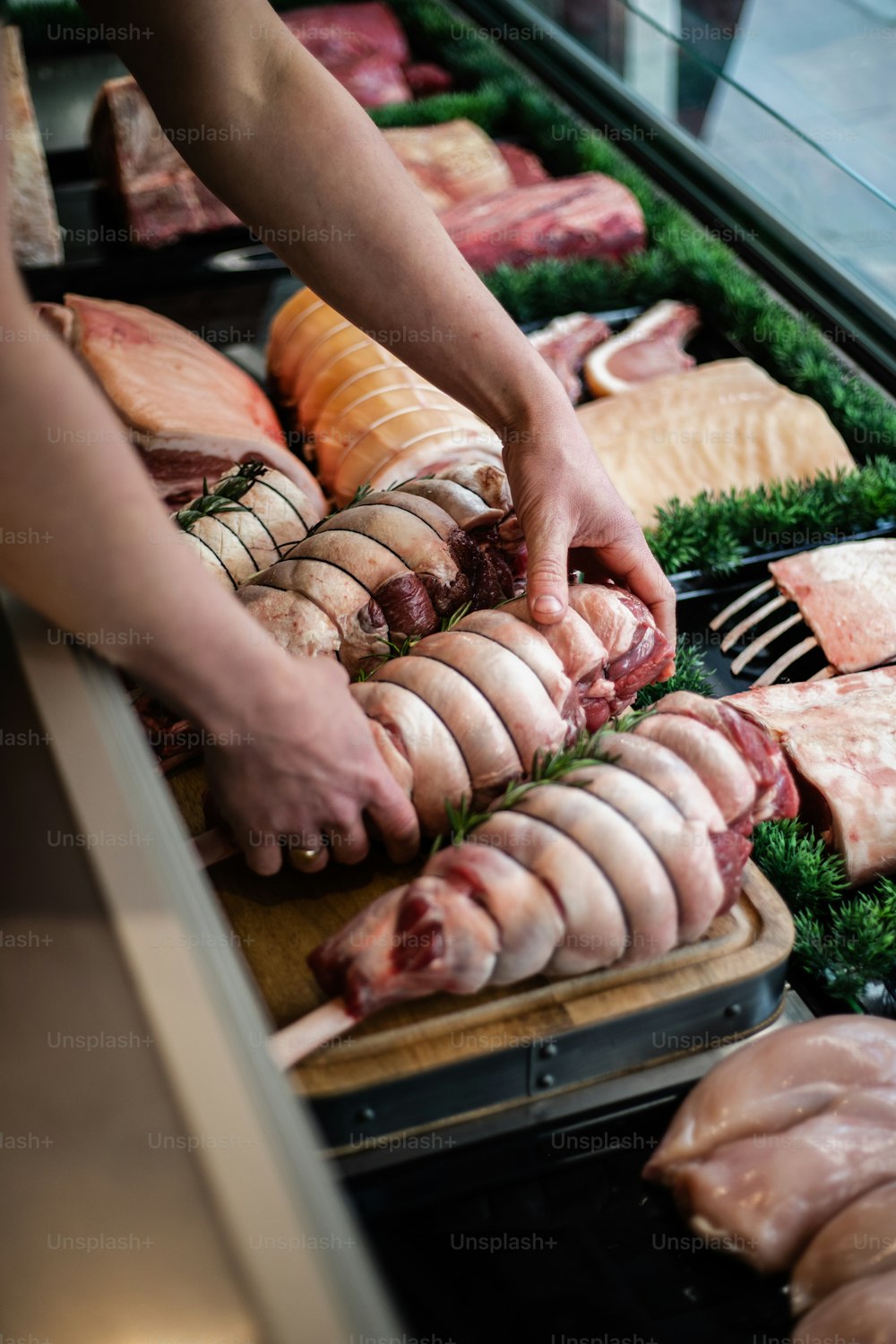 a person cutting meat on a cutting board