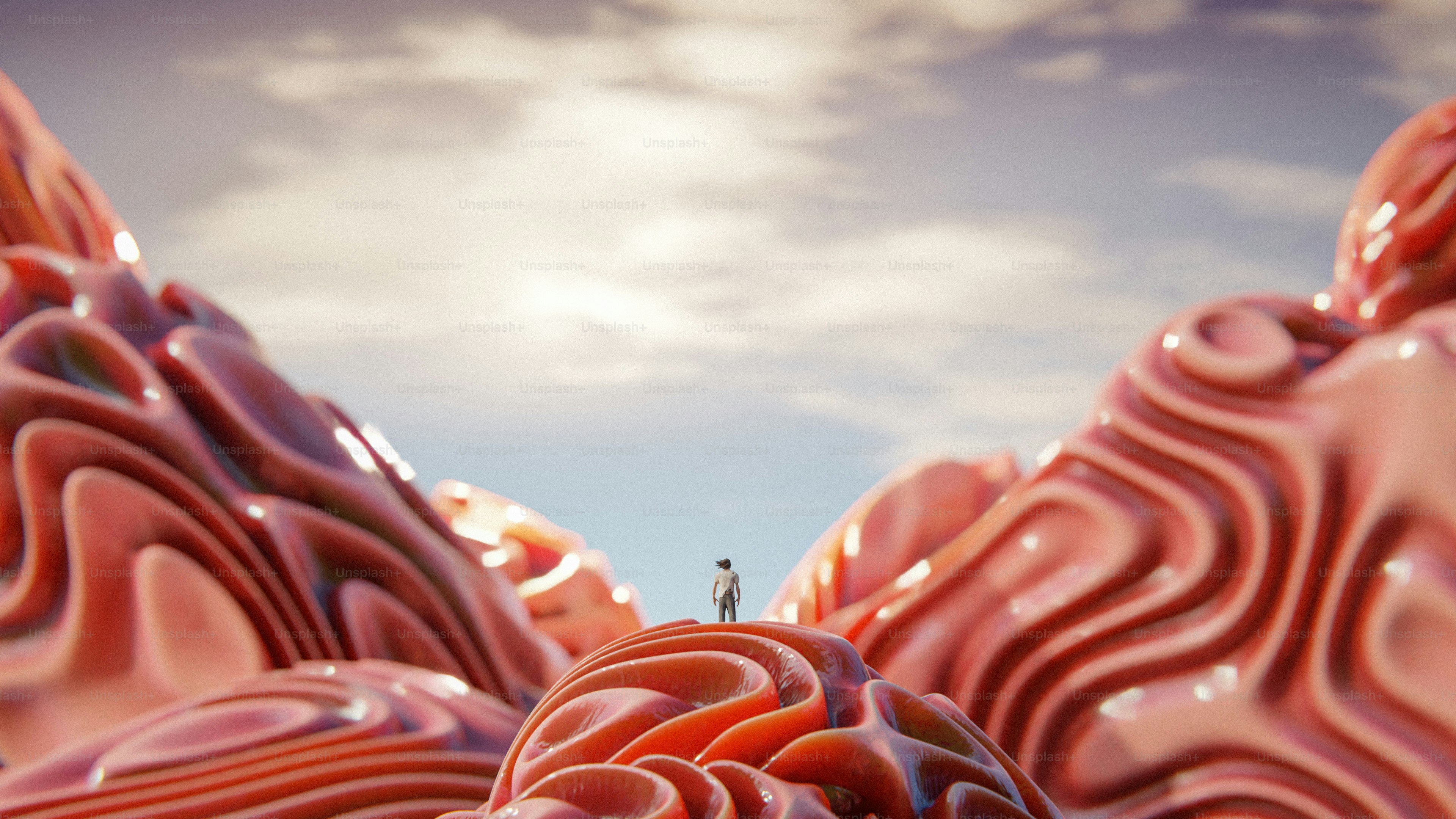 a man standing on top of a hill surrounded by pink hills