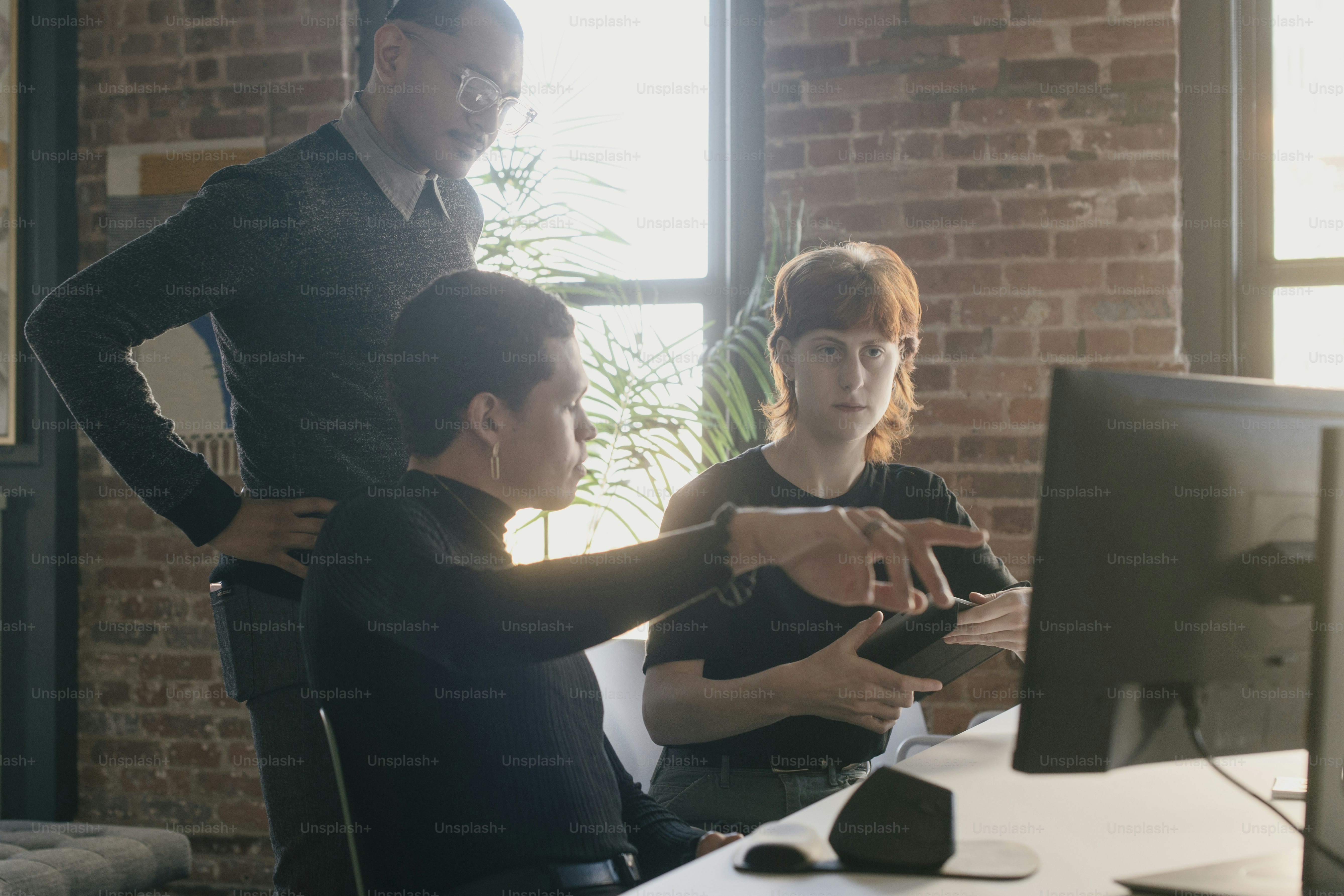 Un hombre y una mujer parados frente a una computadora