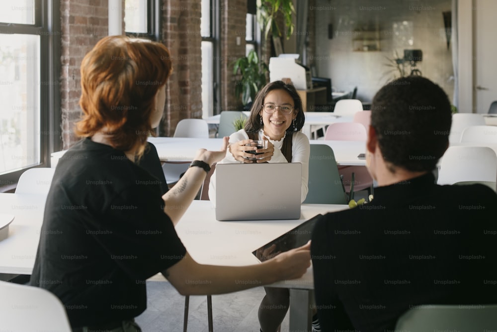 two people sitting at a table with a laptop