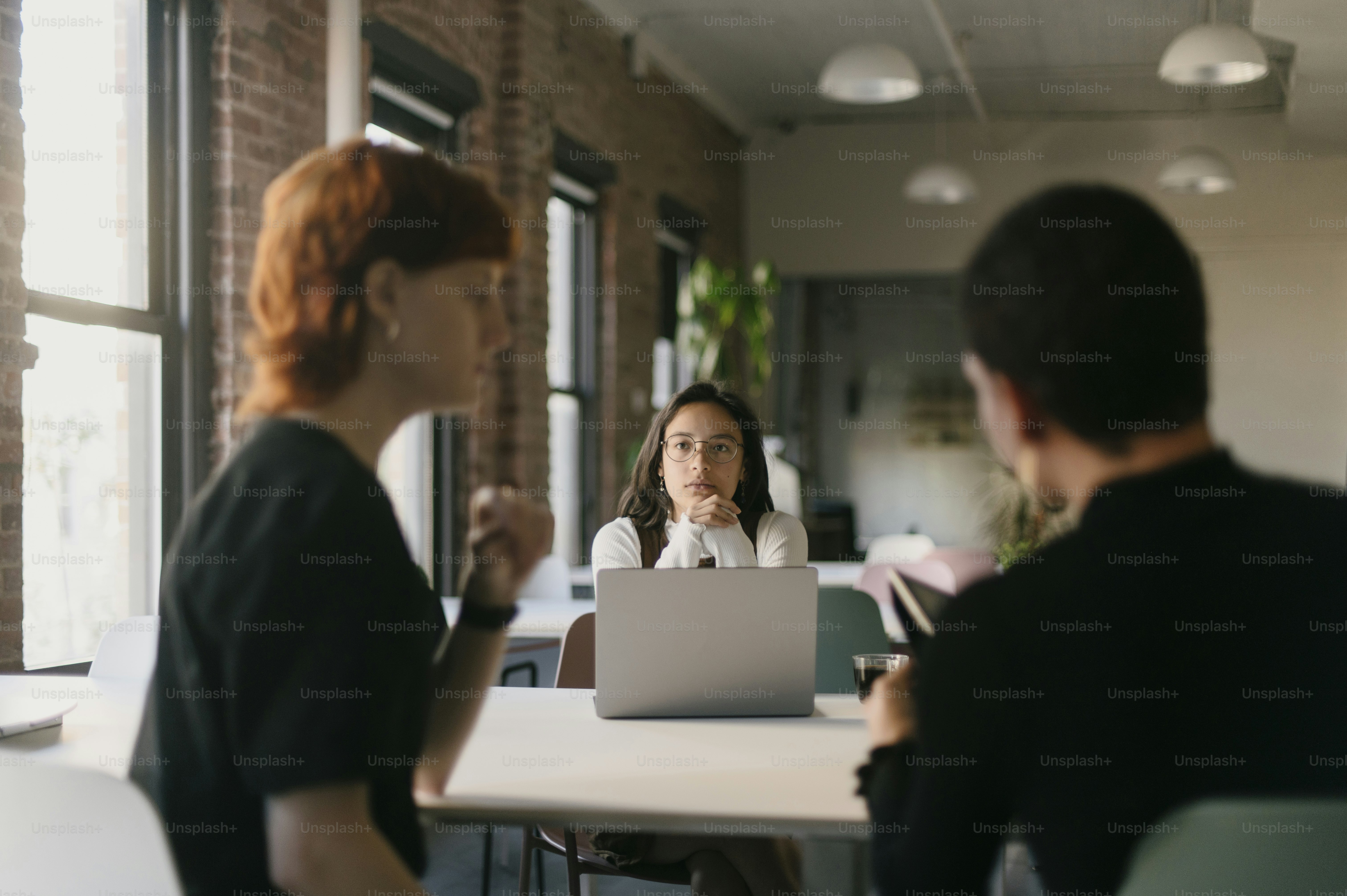 a woman sitting in front of a laptop computer