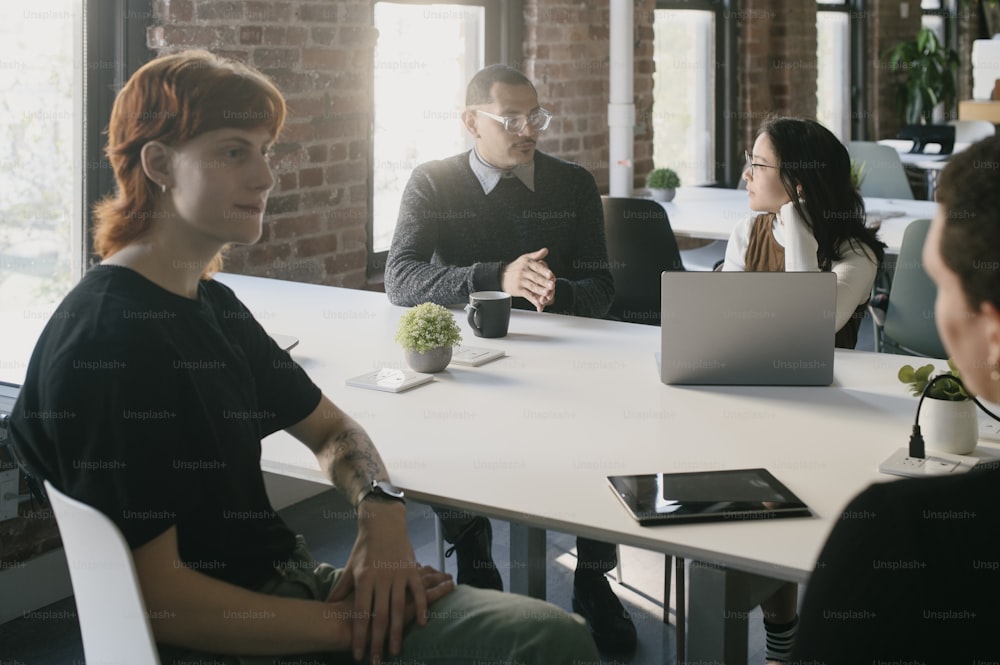 a group of people sitting around a white table