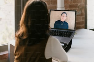 a woman sitting in front of a laptop computer