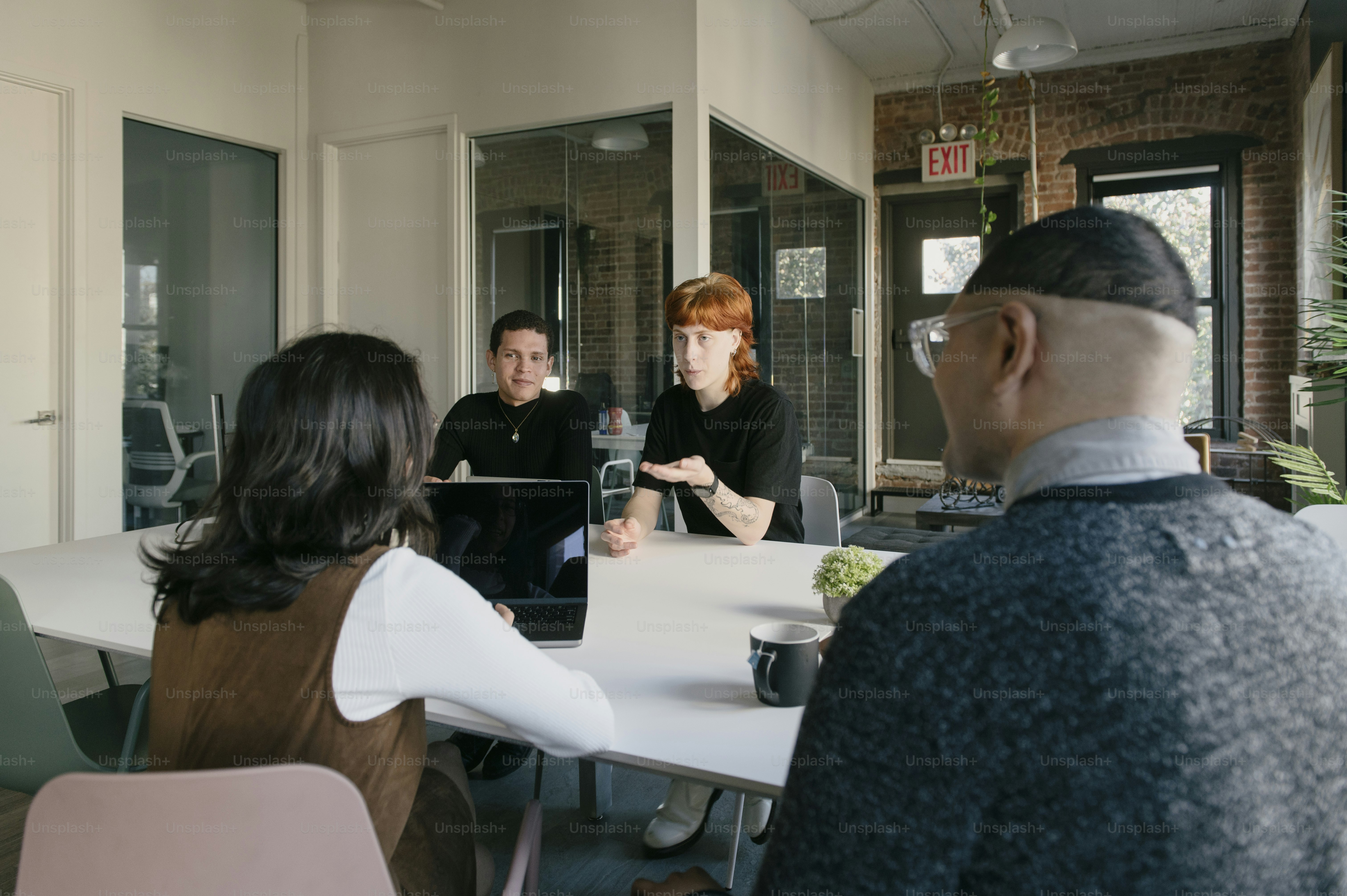 Un grupo de personas sentadas alrededor de una mesa blanca