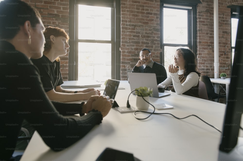 a group of people sitting around a white table