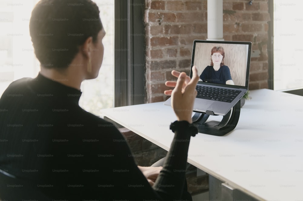 a person sitting at a table with a laptop