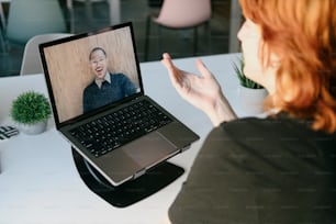 a woman sitting at a table with a laptop