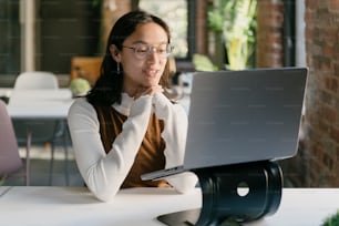 Una mujer sentada frente a una computadora portátil