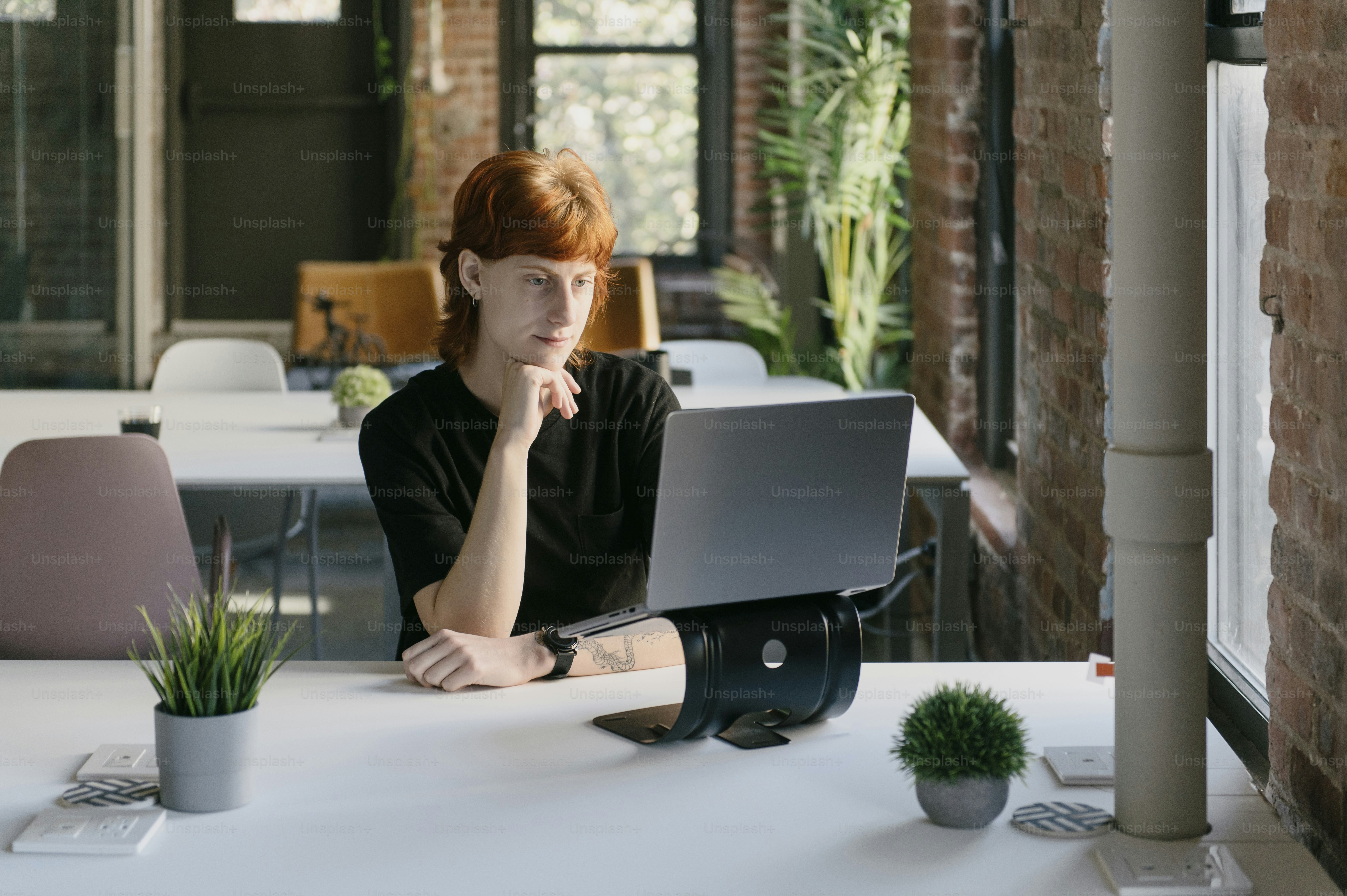 a woman sitting at a table with a laptop