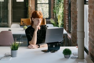 una donna seduta a un tavolo con un computer portatile