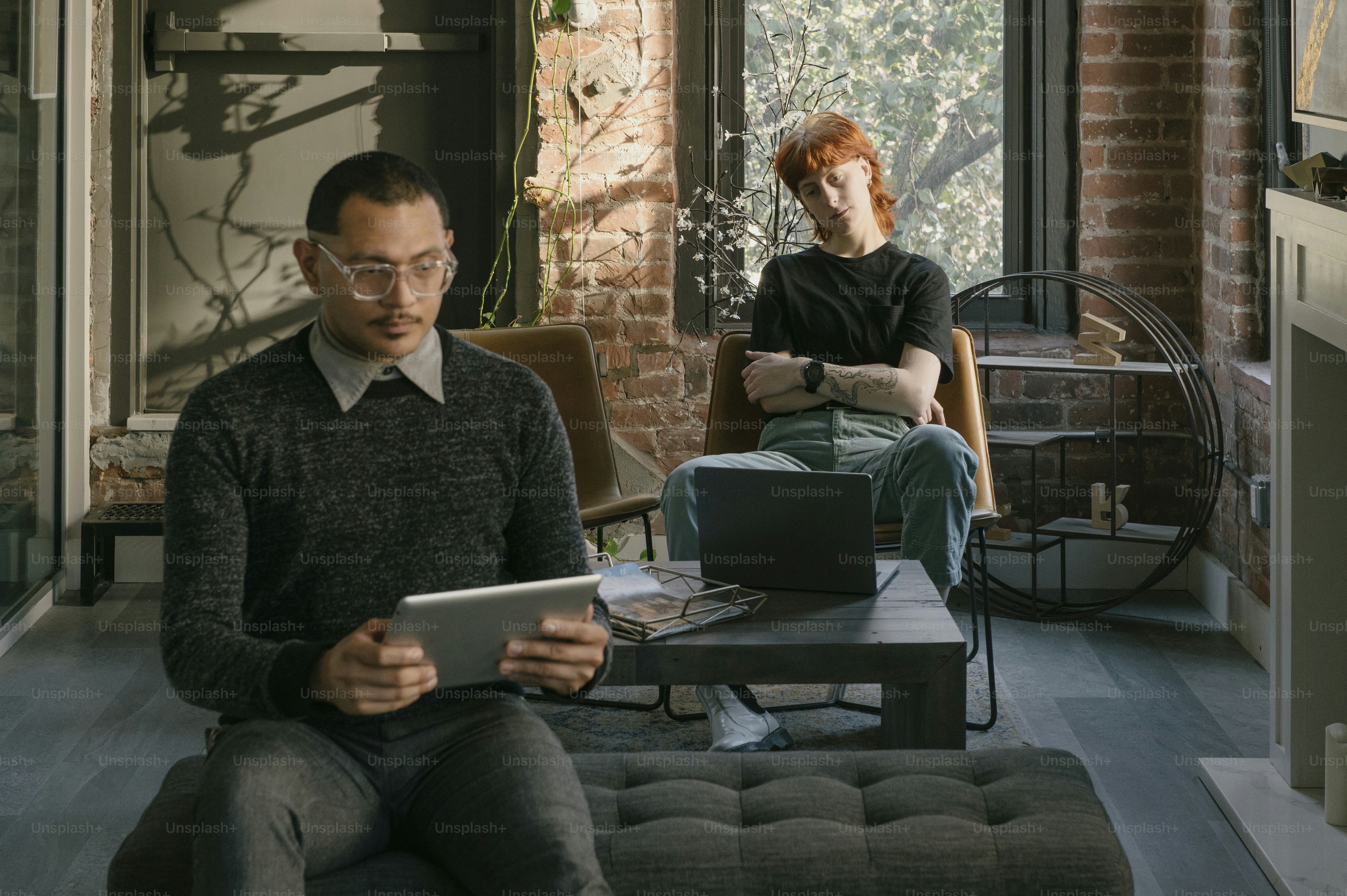 Un hombre y una mujer sentados en un sofá mirando una tableta